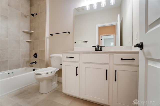 full bathroom featuring tile patterned flooring, tiled shower / bath, vanity, and toilet