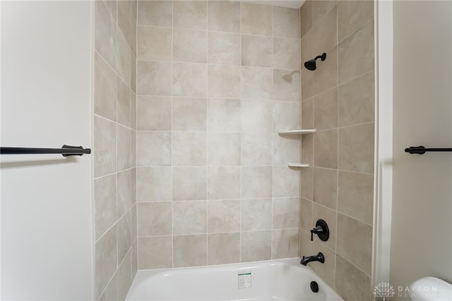 bathroom with tiled shower / bath and toilet