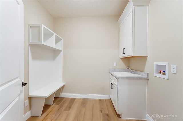 washroom featuring washer hookup, cabinets, light wood-type flooring, and sink