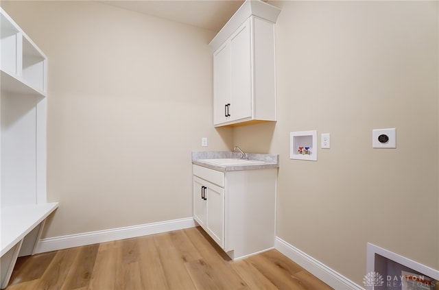 laundry room featuring hookup for a washing machine, hookup for an electric dryer, light hardwood / wood-style flooring, cabinets, and sink