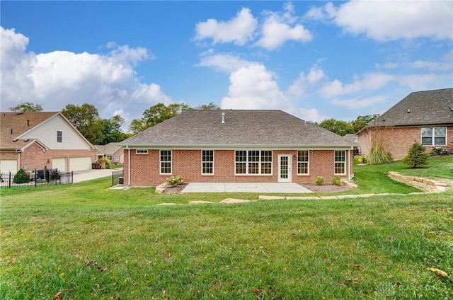 back of house with a garage, a lawn, and a patio area