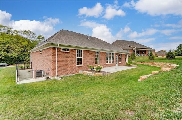 rear view of house featuring a lawn, central AC unit, and a patio area