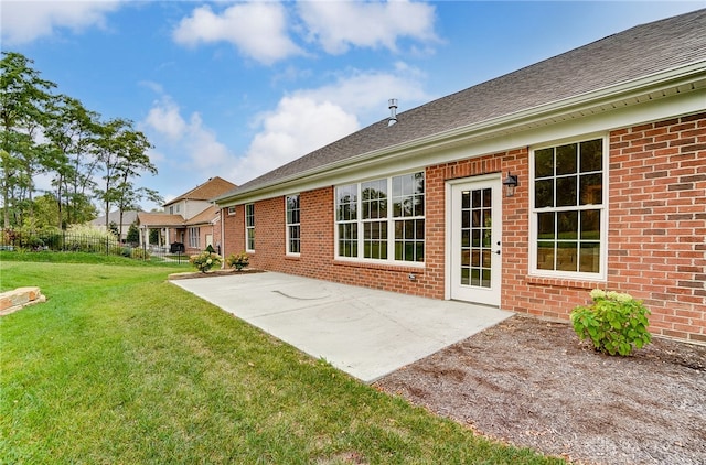 rear view of house featuring a patio and a yard