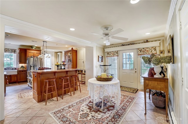 foyer with crown molding, light tile patterned floors, ceiling fan, and plenty of natural light