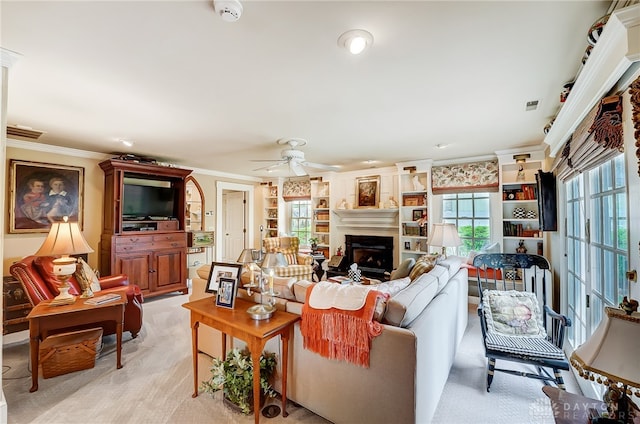 living room featuring ceiling fan, light colored carpet, crown molding, and a healthy amount of sunlight