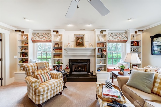 living room featuring a healthy amount of sunlight, crown molding, ceiling fan, and light colored carpet