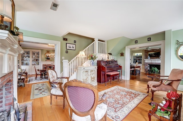 living room featuring light hardwood / wood-style flooring, an inviting chandelier, and a fireplace