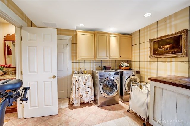 washroom with separate washer and dryer, cabinets, sink, and light tile patterned flooring