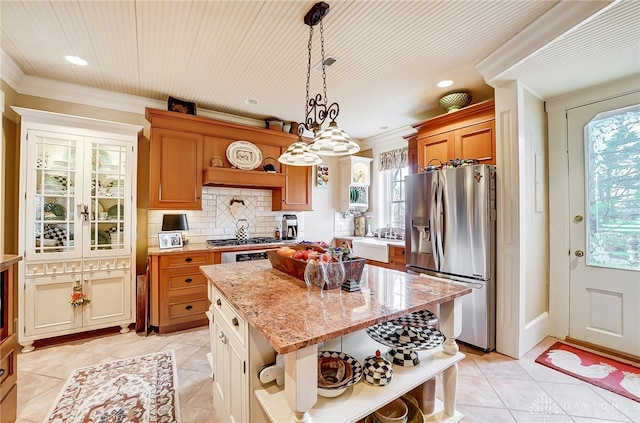 kitchen featuring decorative light fixtures, appliances with stainless steel finishes, plenty of natural light, and a kitchen island