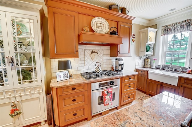 kitchen with light stone counters, tasteful backsplash, stainless steel appliances, crown molding, and sink