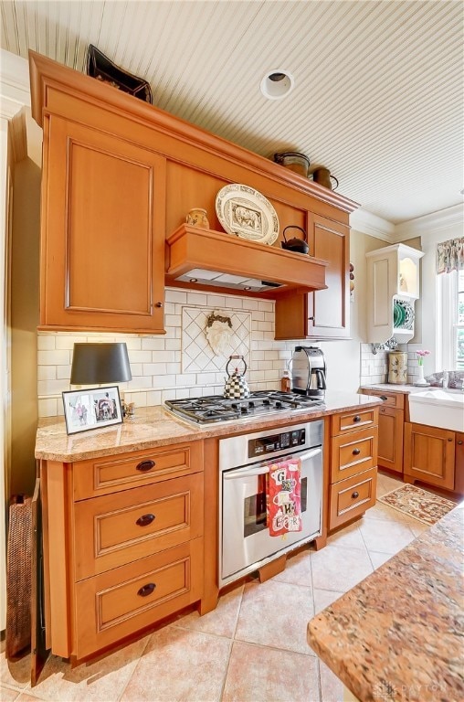 kitchen with sink, light tile patterned floors, stainless steel appliances, and tasteful backsplash