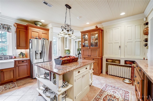 kitchen featuring crown molding, hanging light fixtures, radiator heating unit, and a center island