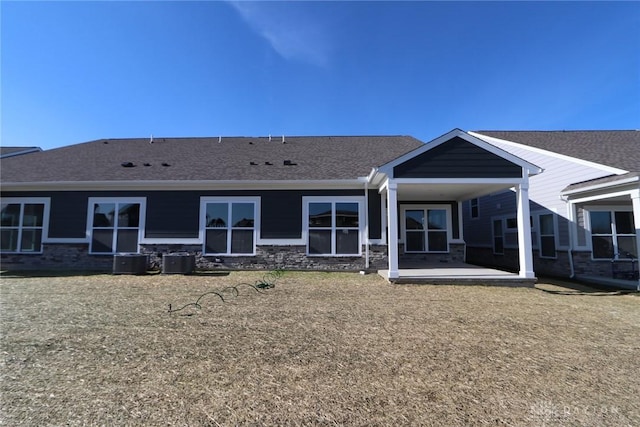 rear view of house featuring a patio, roof with shingles, and cooling unit