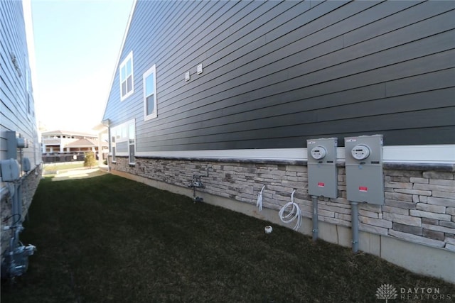 view of side of property featuring stone siding and fence