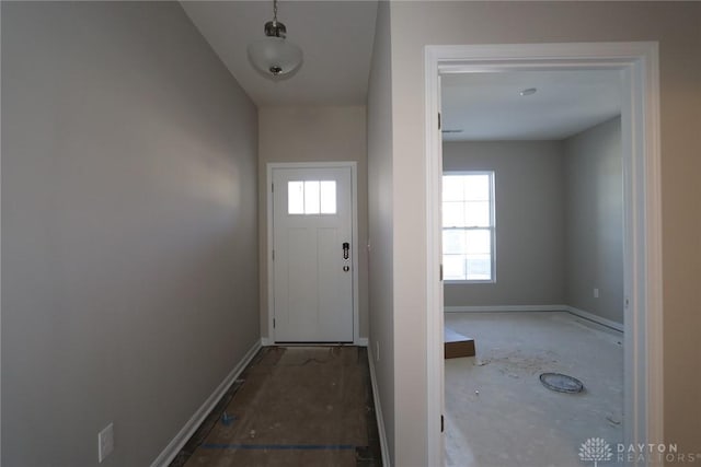 doorway to outside with a healthy amount of sunlight and baseboards