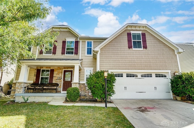 view of front of property featuring a porch, a garage, and a front yard