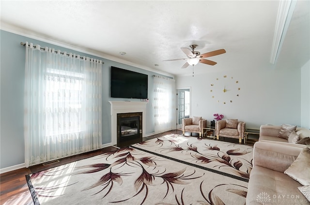 living room featuring ceiling fan, hardwood / wood-style flooring, and crown molding