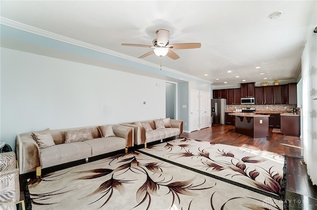 living room with ornamental molding, ceiling fan, and dark wood-type flooring