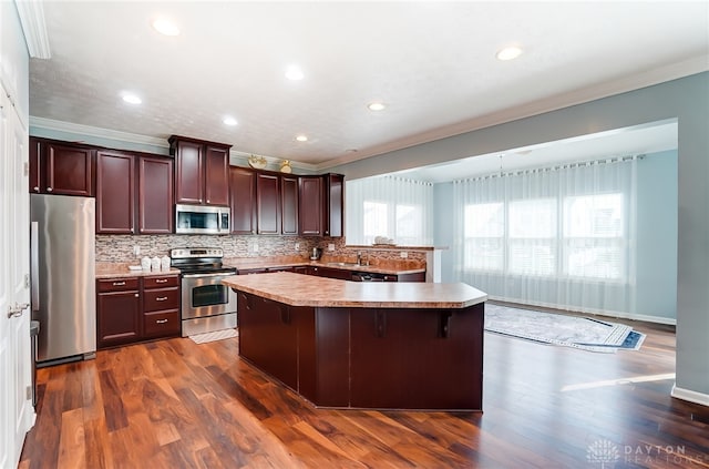 kitchen with stainless steel appliances, dark hardwood / wood-style floors, and a breakfast bar