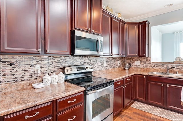 kitchen featuring light hardwood / wood-style floors, tasteful backsplash, sink, stainless steel appliances, and ornamental molding