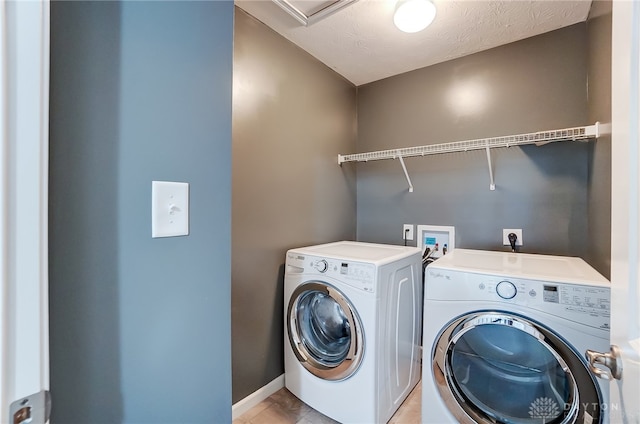 laundry area featuring a textured ceiling and washing machine and dryer