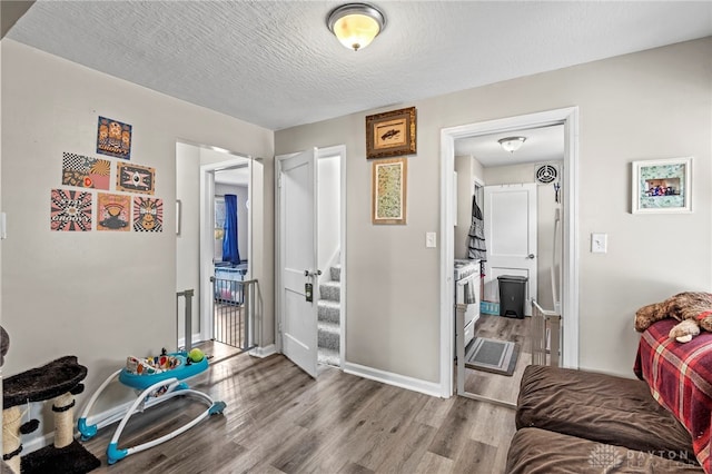 interior space with a textured ceiling and hardwood / wood-style floors