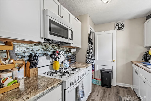 kitchen featuring light hardwood / wood-style floors, a textured ceiling, gas range gas stove, white cabinetry, and dark stone countertops