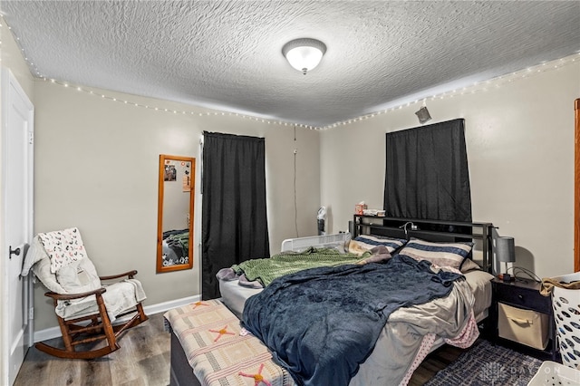 bedroom with wood-type flooring and a textured ceiling