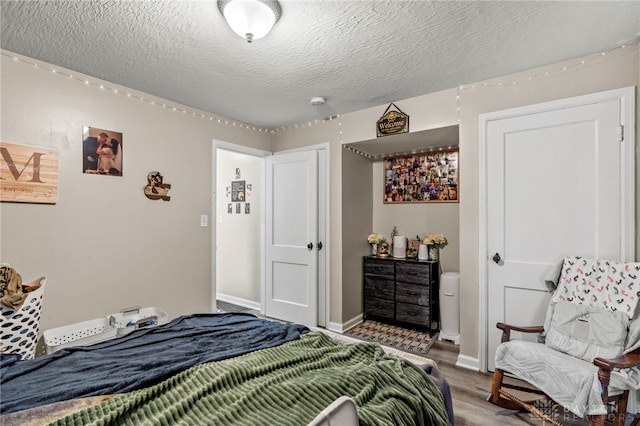 bedroom featuring a textured ceiling and hardwood / wood-style floors