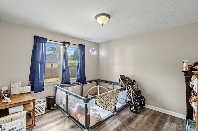 bedroom with wood-type flooring and a textured ceiling