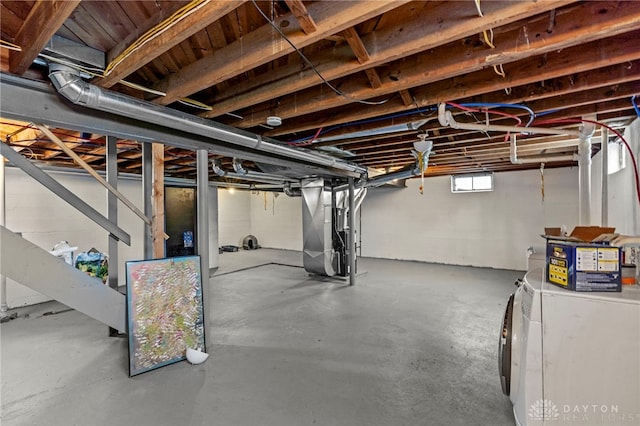 basement featuring heating unit and washer / dryer