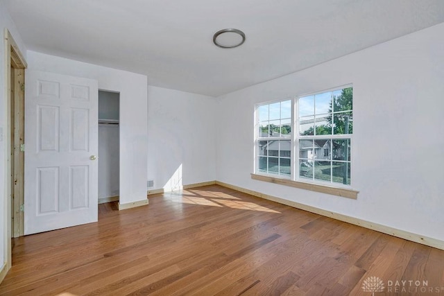 unfurnished bedroom with hardwood / wood-style floors and a closet