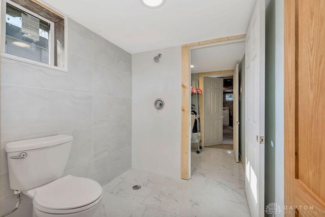 bathroom featuring toilet and tile walls