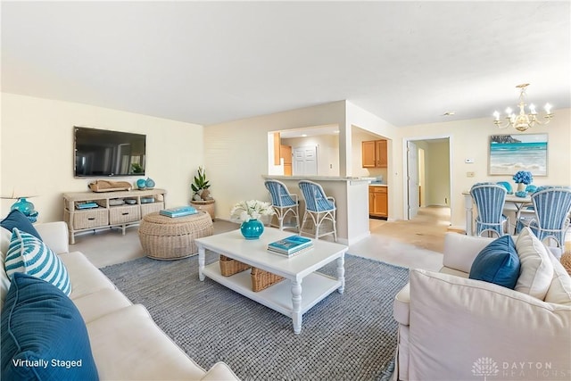 carpeted living room with an inviting chandelier