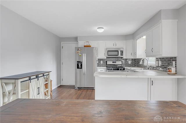 kitchen with wood-type flooring, stainless steel appliances, sink, and white cabinetry