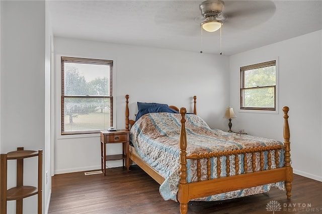 bedroom with multiple windows, ceiling fan, and dark hardwood / wood-style flooring