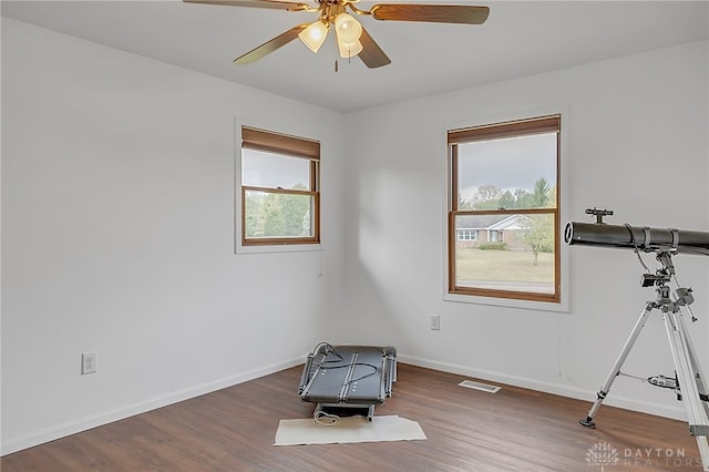 misc room with ceiling fan, dark hardwood / wood-style floors, and plenty of natural light