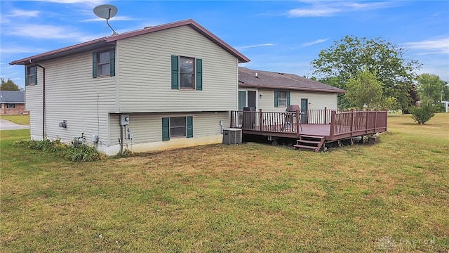 rear view of house featuring a yard, central air condition unit, and a wooden deck