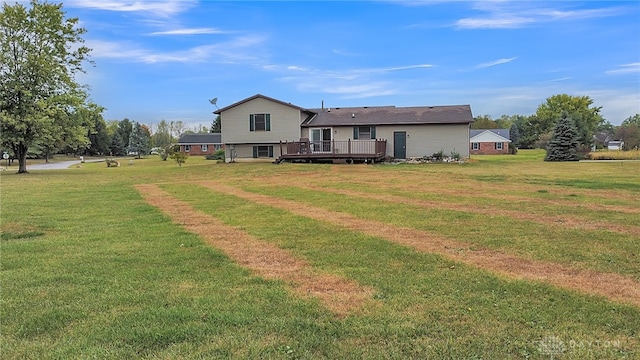 rear view of house with a lawn and a wooden deck