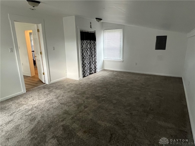 interior space with lofted ceiling and dark carpet