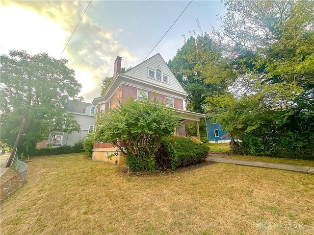 3501 Bevis Ave, Cincinnati, OH 45207 - view of side of home featuring a chimney, brick siding, and a yard