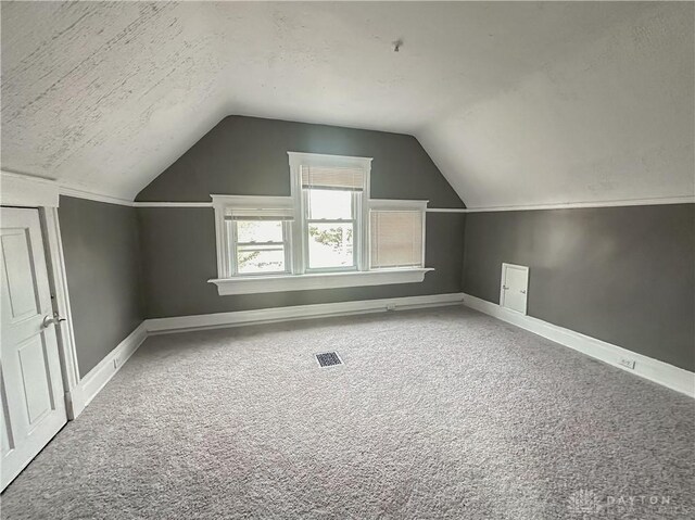 3501 Bevis Ave, Cincinnati, OH 45207 - additional living space with a textured ceiling, baseboards, carpet, visible vents, and lofted ceiling
