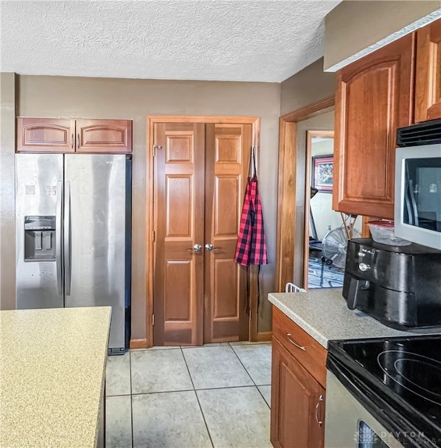 kitchen featuring a textured ceiling, black range with electric cooktop, light tile patterned floors, and stainless steel fridge with ice dispenser