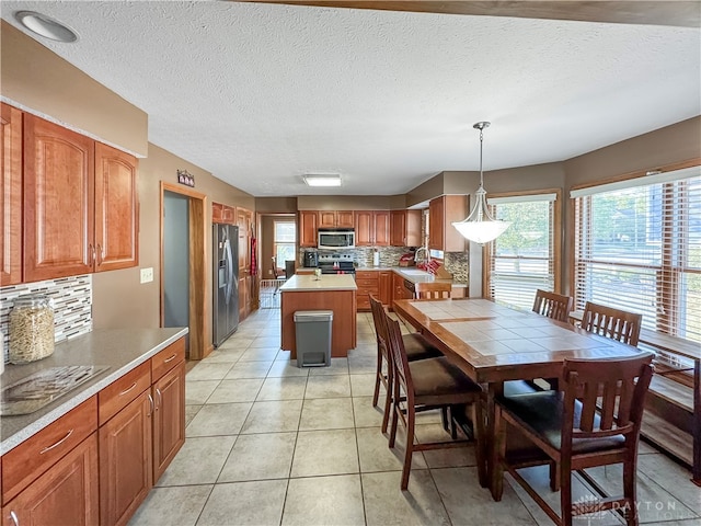 tiled dining room featuring a textured ceiling and sink