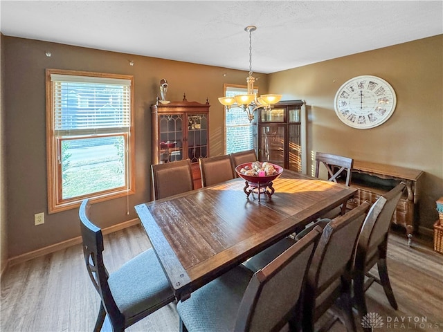 dining space with an inviting chandelier and hardwood / wood-style flooring