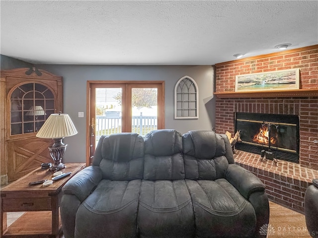 living room featuring a brick fireplace and a textured ceiling