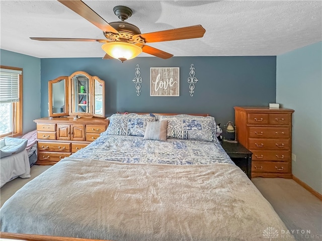 carpeted bedroom with ceiling fan and a textured ceiling