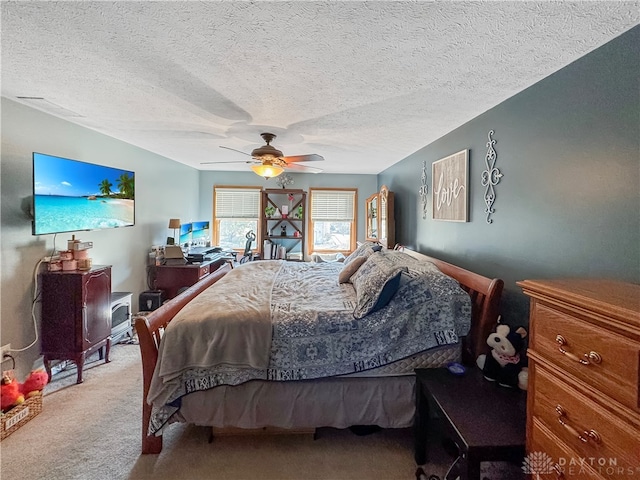 carpeted bedroom with ceiling fan and a textured ceiling