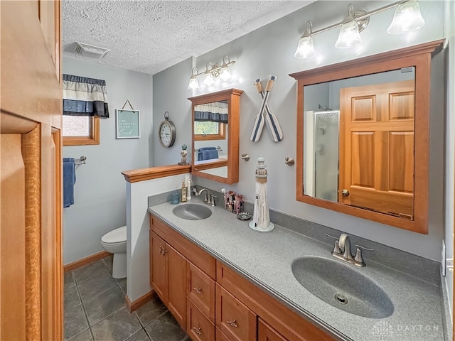 bathroom featuring tile patterned flooring, a textured ceiling, an enclosed shower, vanity, and toilet