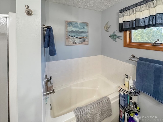 bathroom featuring a textured ceiling and a bathing tub